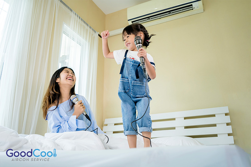 Mother and daughter enjoy singing in a bedroom cooled by an energy-efficient and eco-friendly aircon