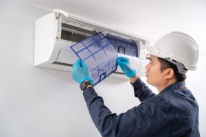 aircon technician removing cleaning air filter