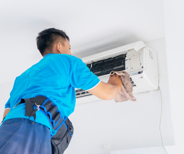 male technician wiping air conditioner