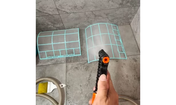 Technician cleaning air filter of air conditioning unit